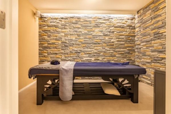A private single treatment room with a massage table and warm lighting