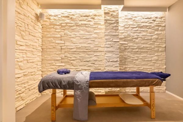 A private treatment room with candles and folded towels